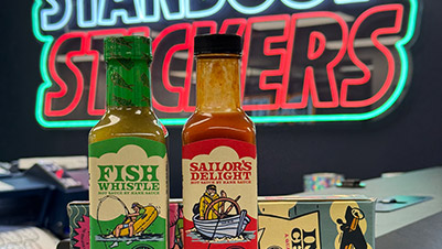 Bottles of Hank Sauce with the Standout Stickers Neon Sign